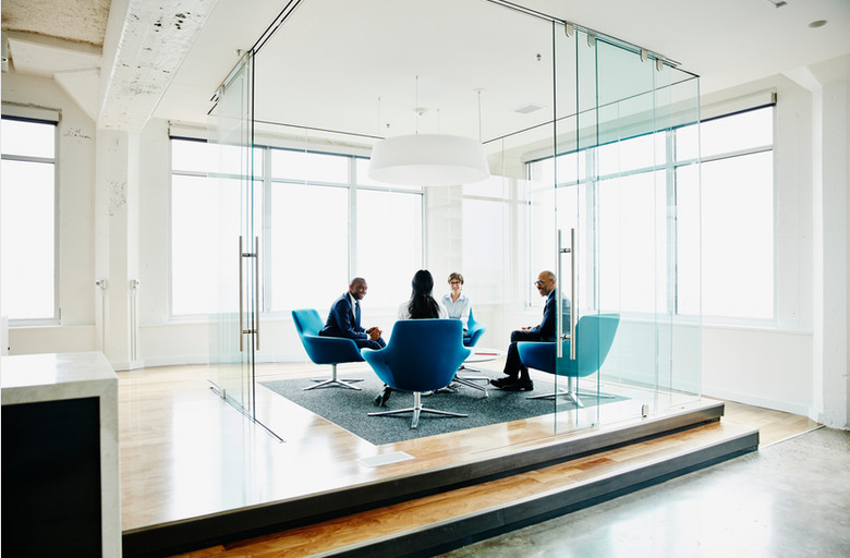Business professionals meeting in a bright glass conference room