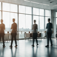 Softly silhouetted business professionals in a bright, elegant boardroom
